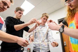 Students construct a tensegrity model in an engineering lab.